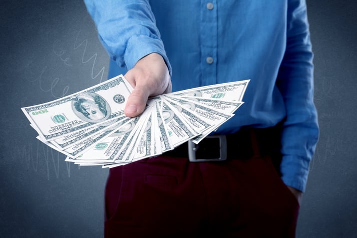 Young businessman holding large amount of bills with grungy background